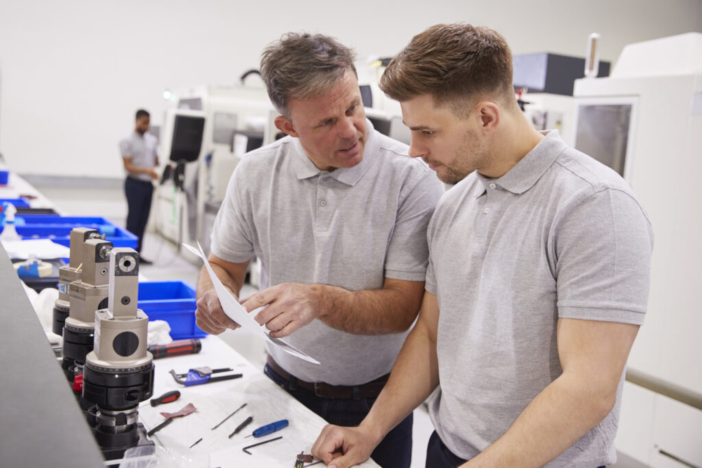 Engineers discussing metal parts solution In Factory